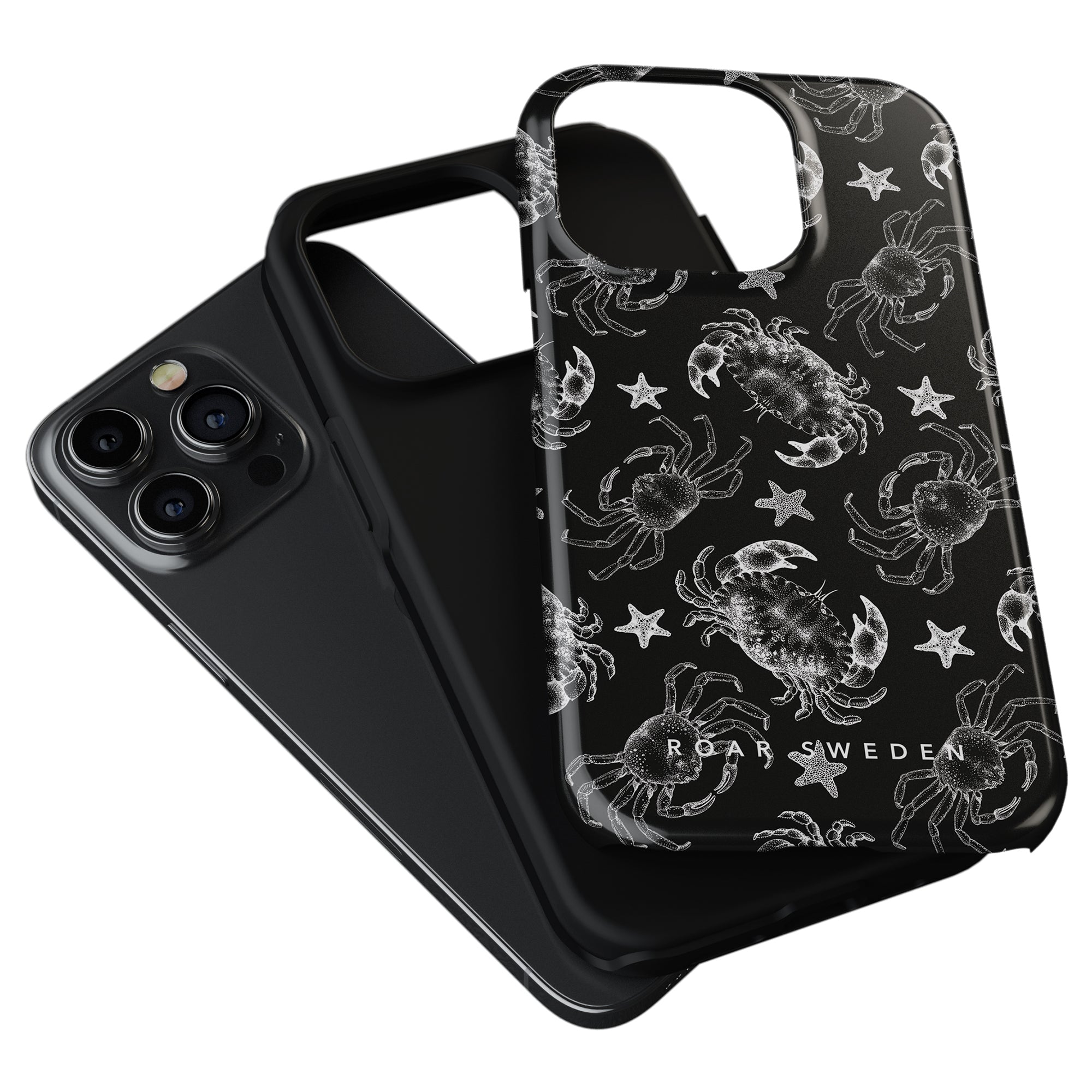 A Black Crab - Tough Case with a white crab and starfish design, from the Ocean Collection, is shown leaning against a plain black smartphone case.