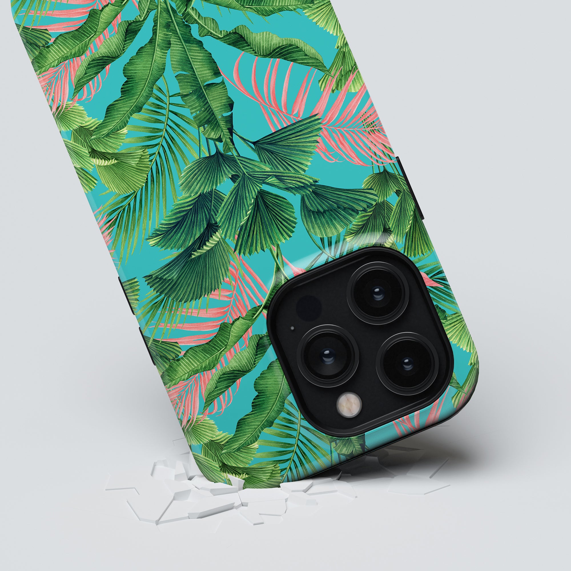 A smartphone with a Palm Breeze Tough case from the Jungle Collection lies face down on a surface, with cracks visible near the phone's corner.