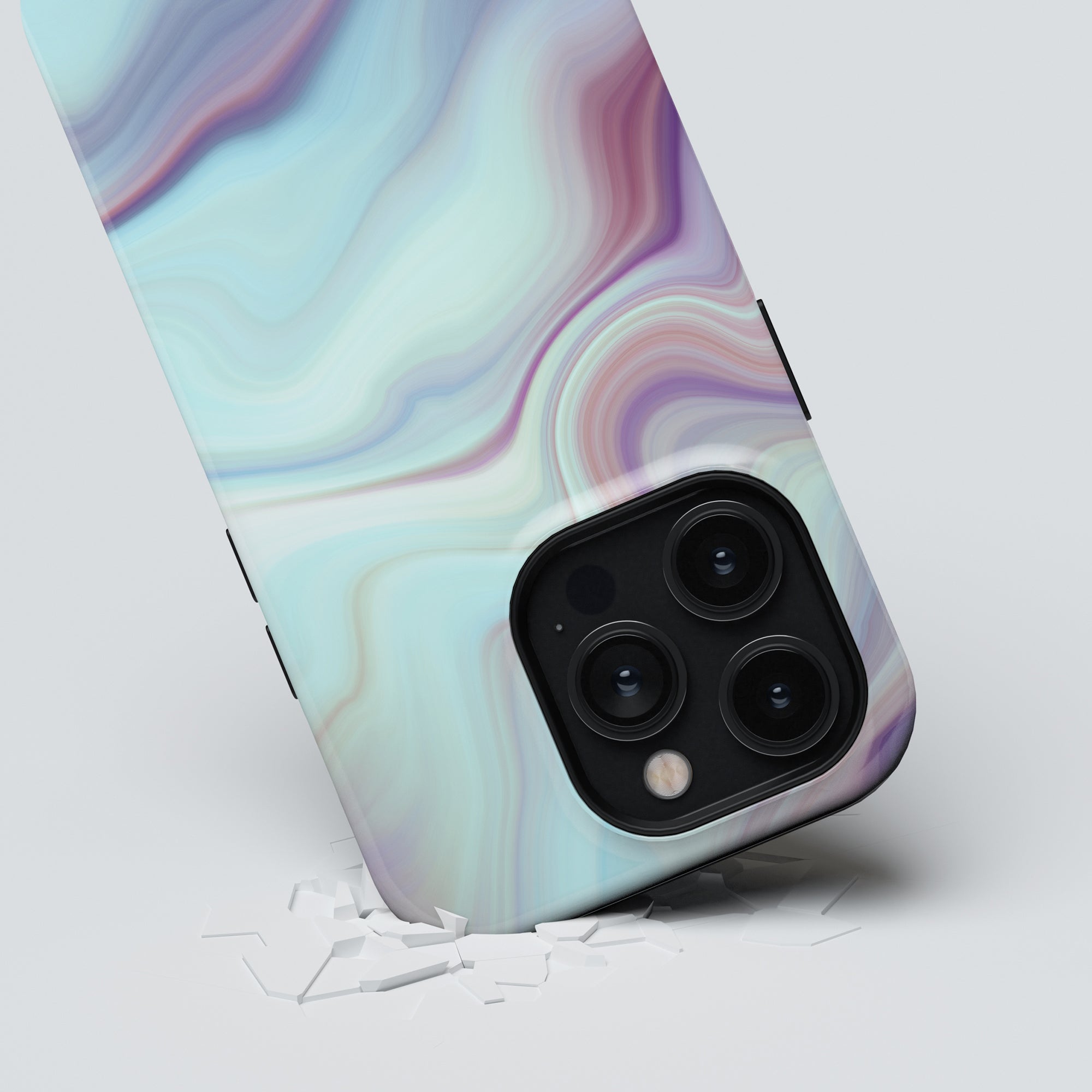 Close-up of a smartphone with a triple camera system, breaking through a white surface. The phone's case features an Abalone - Tough Case design from the Oyster Collection.