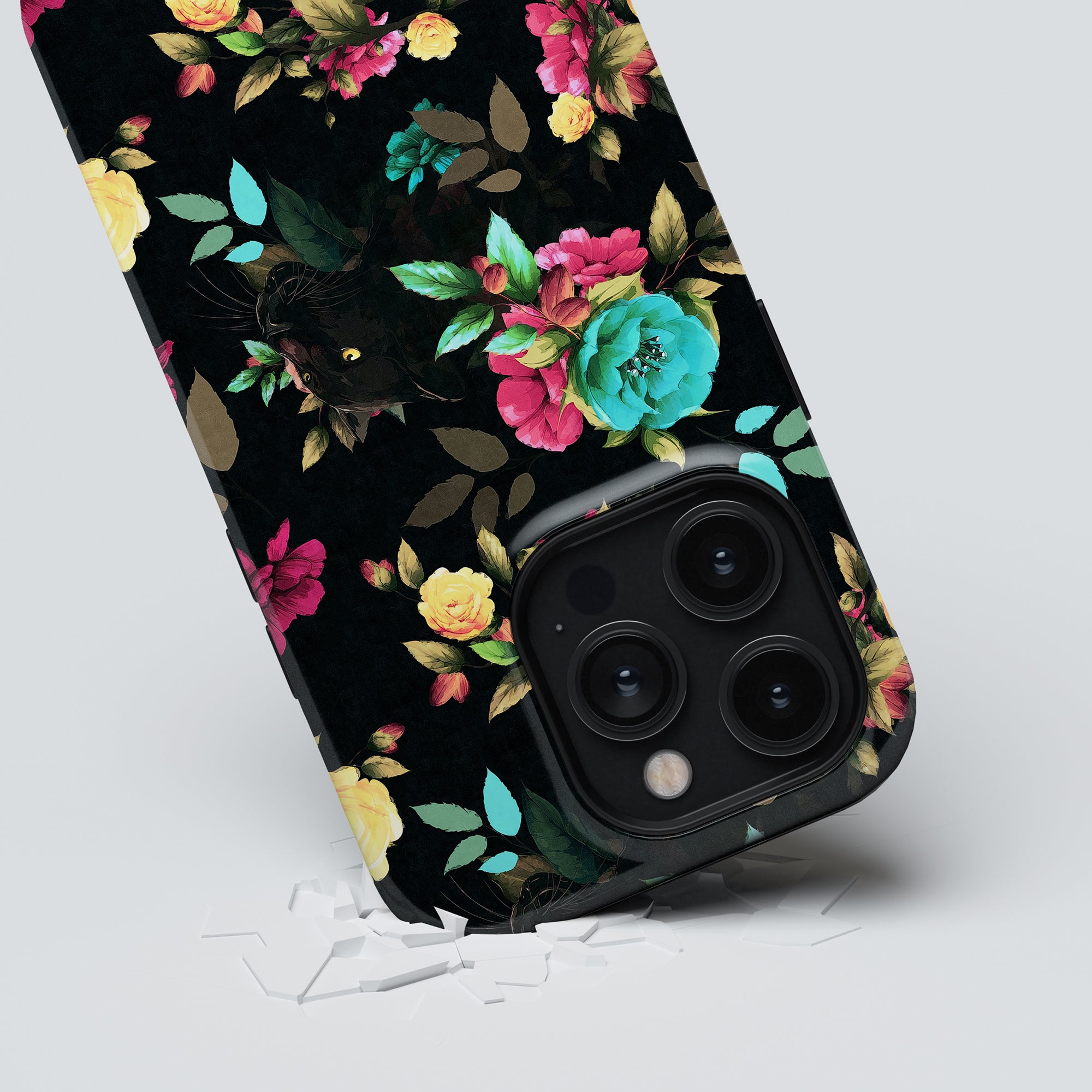 Bloom Panther - Tough Case with a floral tough case partially submerged in a white surface, showcasing its prominent triple-lens camera system.