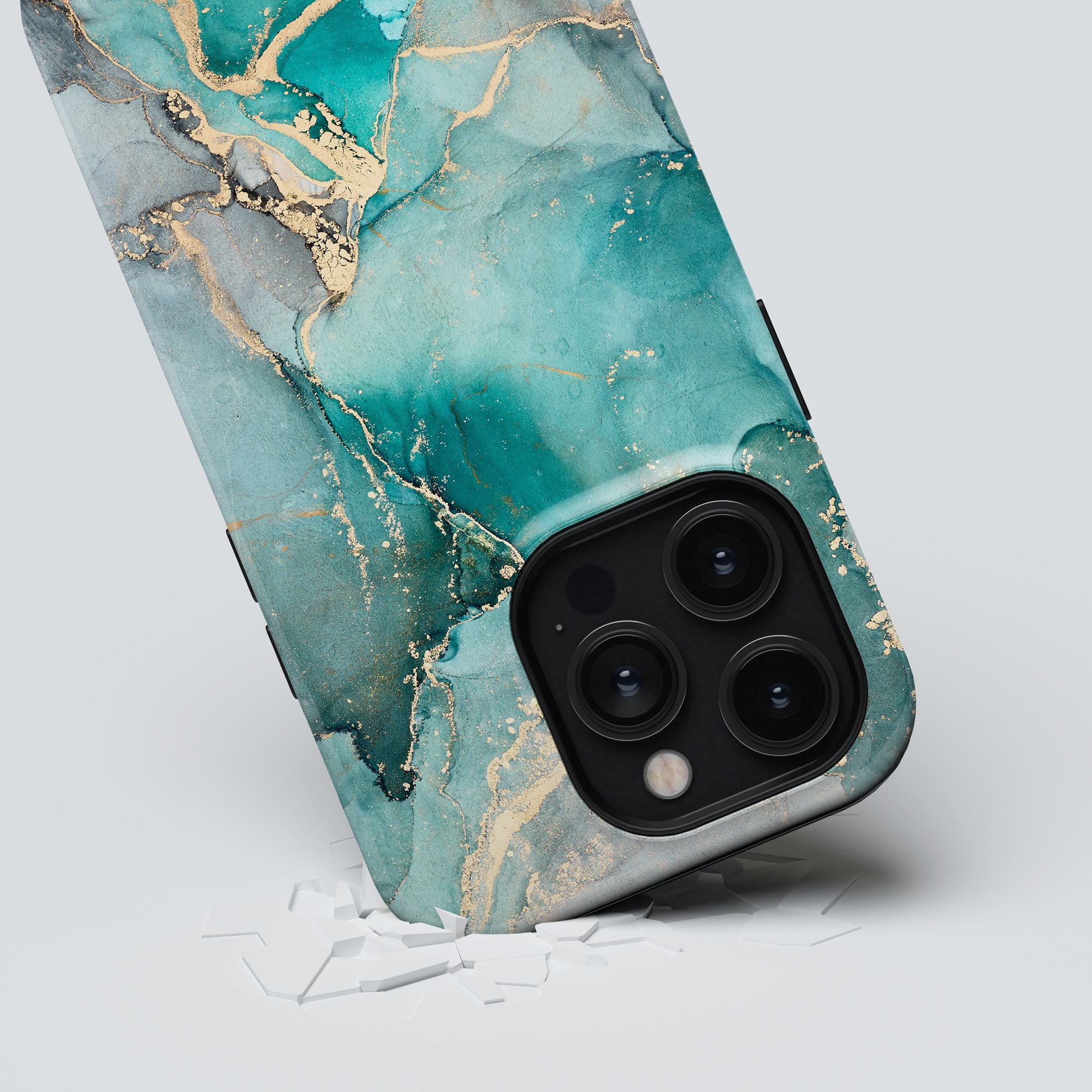 Ferozah - Tough Case with a turkos marmor and gold marbled case breaking through a white surface, showcasing its triple-lens camera system.