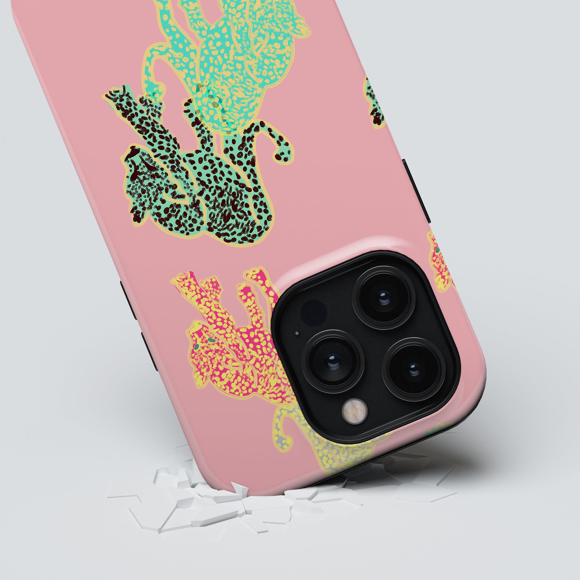 Pink smartphone with a colorful Meow - Tough Case and a triple-lens camera, falling and causing the surface to crack on impact.
