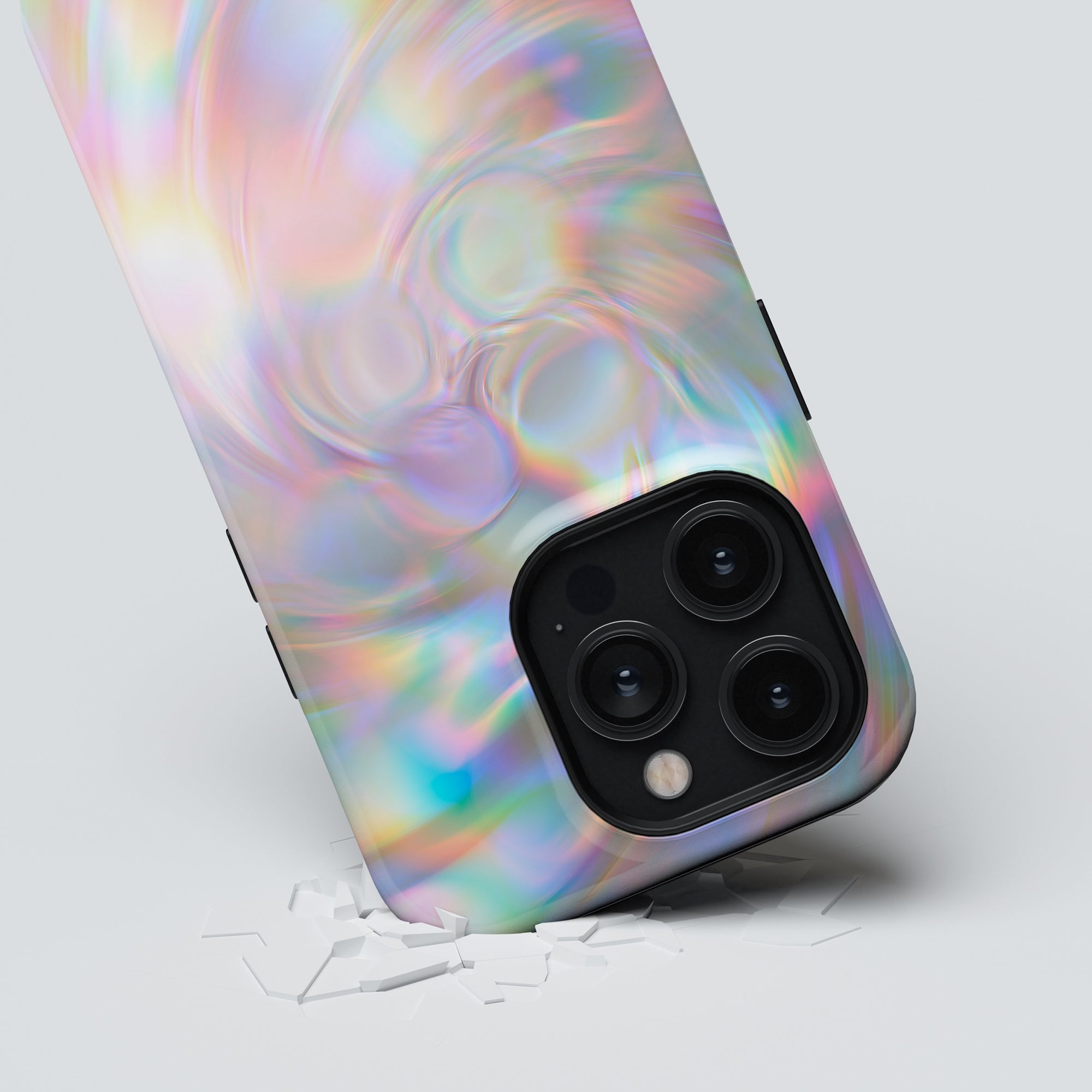 A smartphone with a holographic back and triple camera setup partially embedded in a white Pearl tough case, causing small cracks around it.